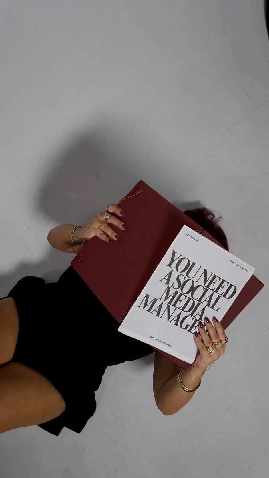 Dark cherry folder with a social media management printout